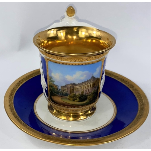 519 - A late KPM cabinet cup and saucer in blue and gilt with figural handle and panels, polychrome panel ... 