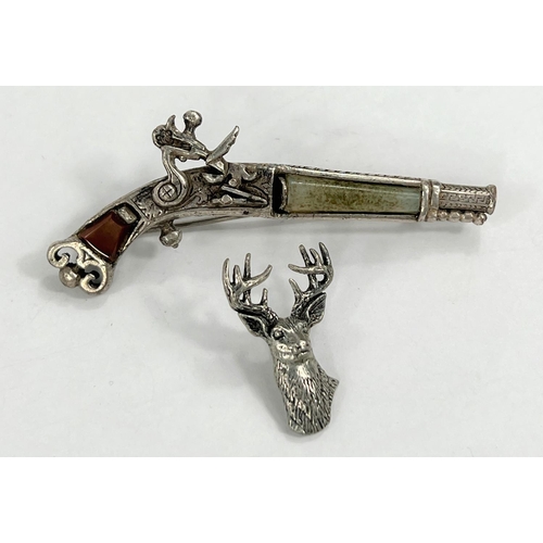 606 - A white metal Scottish brooch in the form of a pistol with a white metal stags head.