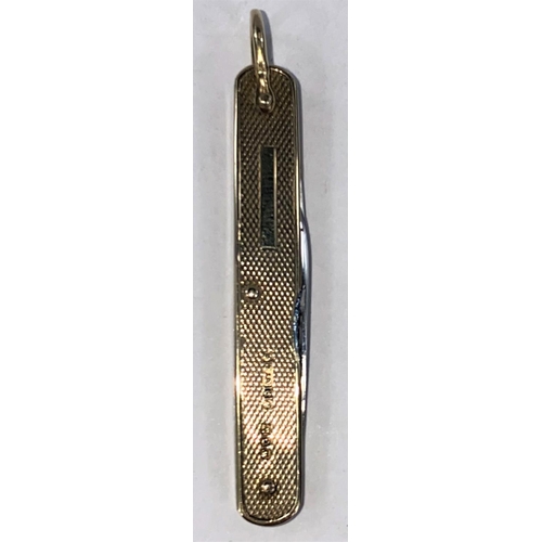 704 - A 2 blade purse knife, 9 carat gold sides, engine turned decoration, 6.3 cm