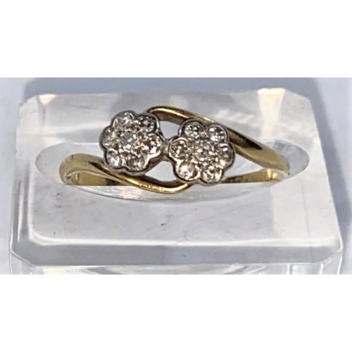 705 - An 18 carat gold dress ring with twin diamond set flower heads in crossover setting