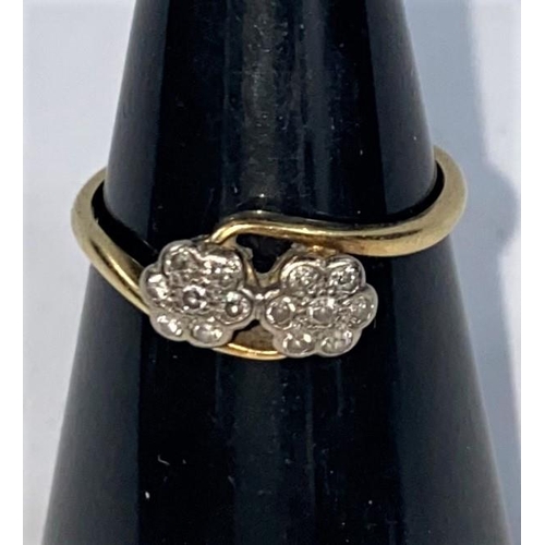 705 - An 18 carat gold dress ring with twin diamond set flower heads in crossover setting