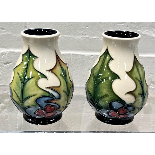 426 - A modern Moorcroft pair of small baluster vases 'Holly and Berries'  decorated with holly leaves and... 