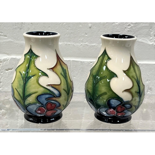 426 - A modern Moorcroft pair of small baluster vases 'Holly and Berries'  decorated with holly leaves and... 