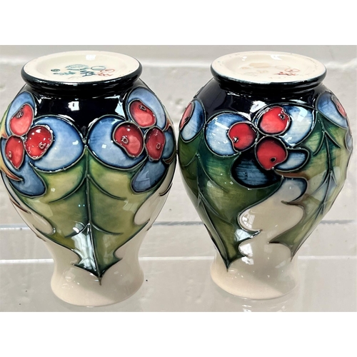 426 - A modern Moorcroft pair of small baluster vases 'Holly and Berries'  decorated with holly leaves and... 