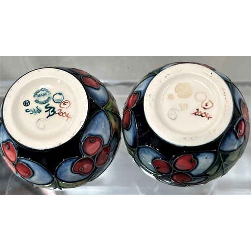 426 - A modern Moorcroft pair of small baluster vases 'Holly and Berries'  decorated with holly leaves and... 