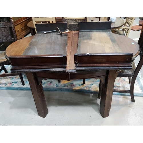 876 - An early 20th century oak wind out dining table with oval top, 2 spare leaves, on beaded square legs... 