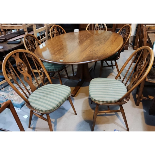 892 - A modern Ercol medium elm dining suite comprising large oval table on central pedestal, and 6 wheel ... 