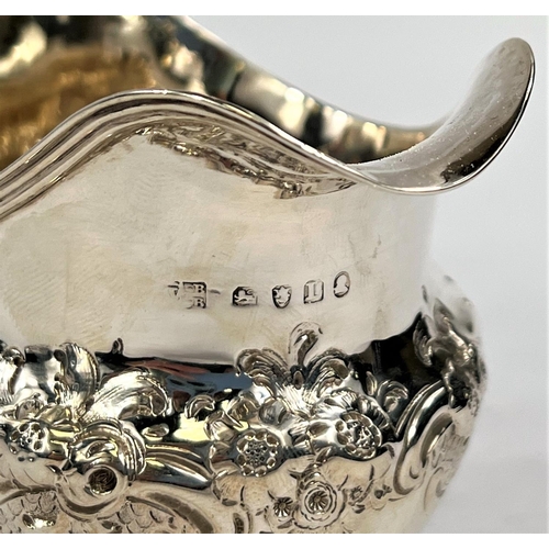 751 - A Georgian hallmarked silver milk jug with embossed floral decoration, London 1806, 3.6oz.