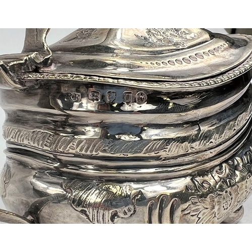 753 - A Georgian hallmarked silver hinged sugar pot with embossed decoration and Bristol blue glass l... 