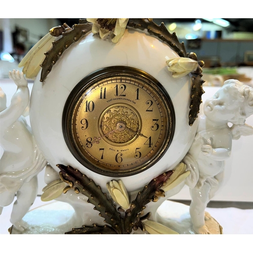 512 - A 19th century Moores porcelain mantel clock, supported by 2 cherubs with flowering cactus mounts, g... 