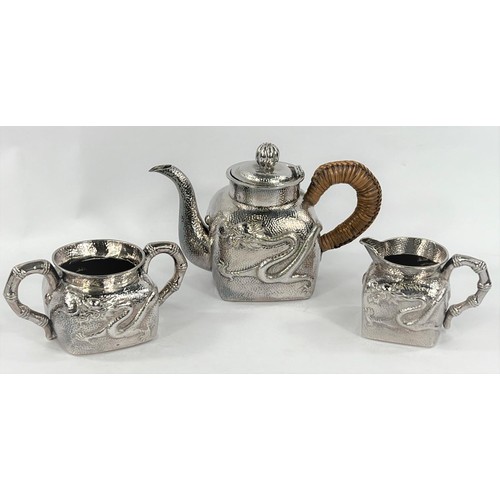 601 - An early - mid Chinese, 3 piece white metal tea set of square form, planished with raised dragon dec... 