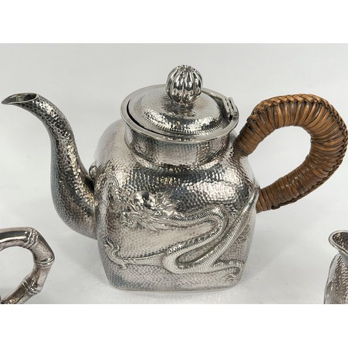 601 - An early - mid Chinese, 3 piece white metal tea set of square form, planished with raised dragon dec... 