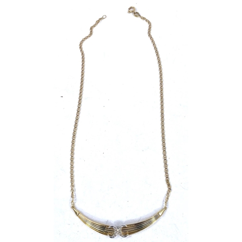 689 - A 2 tone metal necklace, stamped '750', the central ribbed pendant set diamond studded back to back ... 