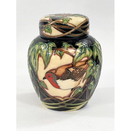 432 - A modern Moorcroft covered ginger jar 'Robin' decorated with robins on leafy branches, with holly an... 