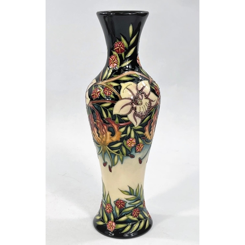 433 - A modern Moorcroft tall slender baluster vase 'Gloriosa Lily' decorated with flowers, leaves and ber... 