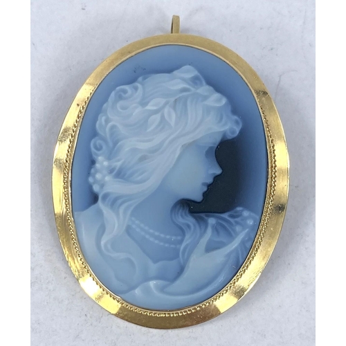 692 - A cameo brooch in blue and white agate, in yellow metal frame stamped '750', overall length 35mm