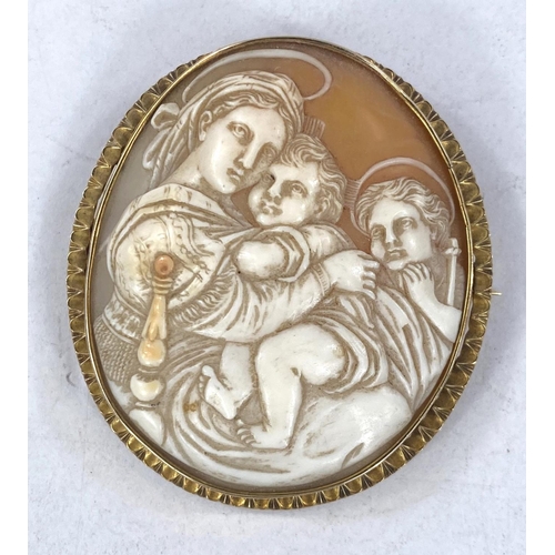 693 - A large shell cameo brooch depicting the Holy Family, in unmarked yellow metal frame