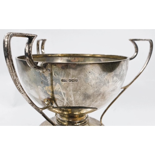 748 - A hallmarked silver triple handled bowl/cup on pedestal foot, Sheffield 1908 14.0 oz on ebonised ste... 