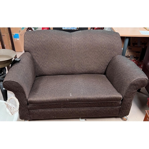 920 - An early 20th century two seater drop end sofa in brown.