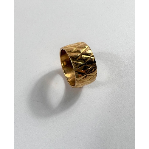 613 - A 22 carat hallmarked gold wide wedding ring with diamond pattern, 9.33gm