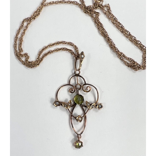 629 - An Edwardian yellow metal pendant set with peridots and seed pearls on yellow metal chain tested as ... 