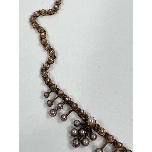 630 - A Victorian yellow metal necklace, each link set with a seed pearl, tiered drops, the central with a... 