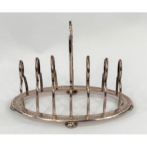 720 - A hallmarked silver gothic arch toast rack with 6 divisions on chased oval base and 4 beaded pad fee... 