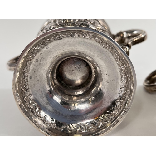 731 - A hallmarked silver pair of Irish cast loving cups with twin handles, extensive relief decoration of... 