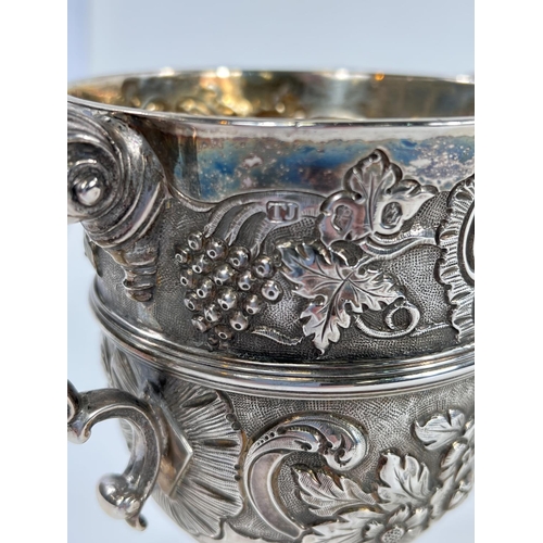 731 - A hallmarked silver pair of Irish cast loving cups with twin handles, extensive relief decoration of... 