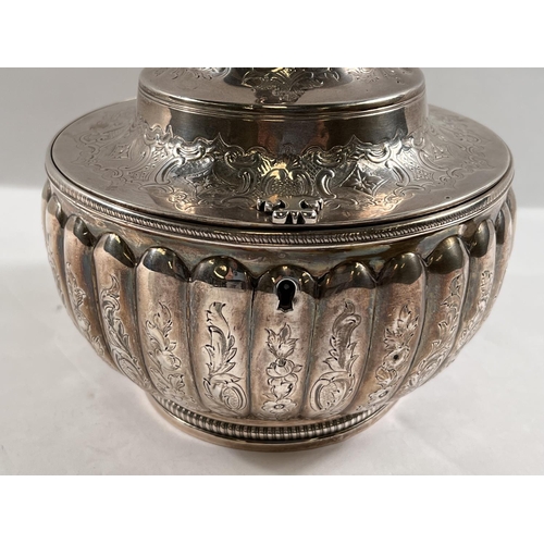 789 - A George III silver tea caddy of melon form, engraved decoration, waisted domed lid with figural fin... 