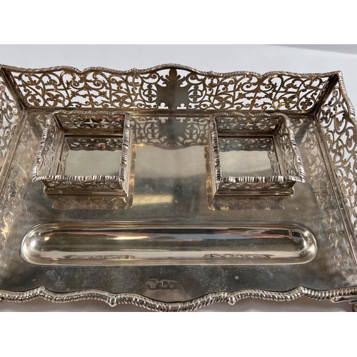 790 - A silver standish with pierced scrollwork gallery and gadrooned border, carried on scrolled feet wit... 