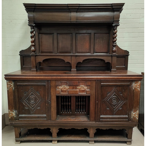 1011 - A large 19th century Jacobean style dresser, raised panel back, two carved end cupboards central dol... 