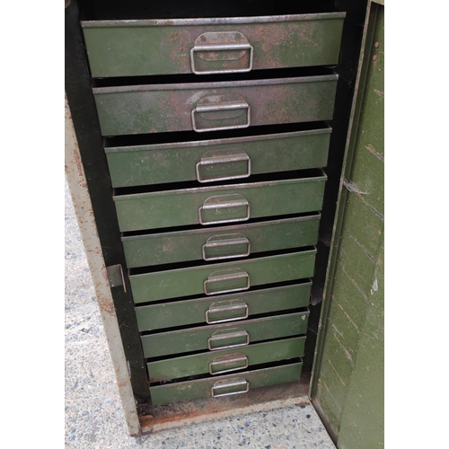 25B - A metal industrial collectors cabinet with swing door and interior drawers, tray top