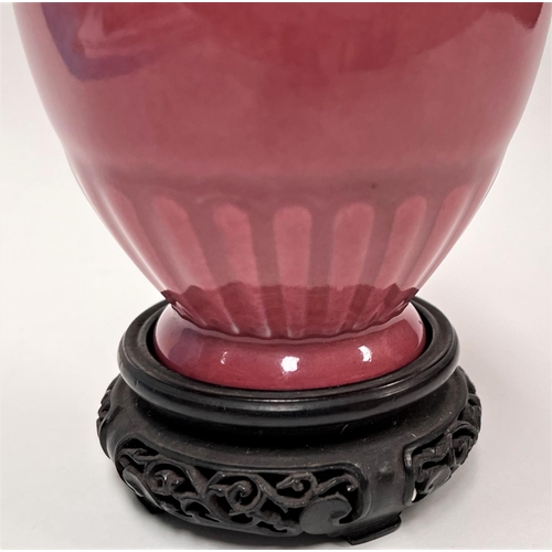 463 - A Chinese light pink vase with lotus style decoration, 6 character mark to base, with hardwood stand... 