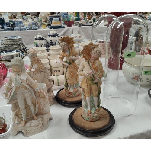 583 - A Victorian pair of coloured bisque figures under glass domes; a similar pair of spill vases/figures... 