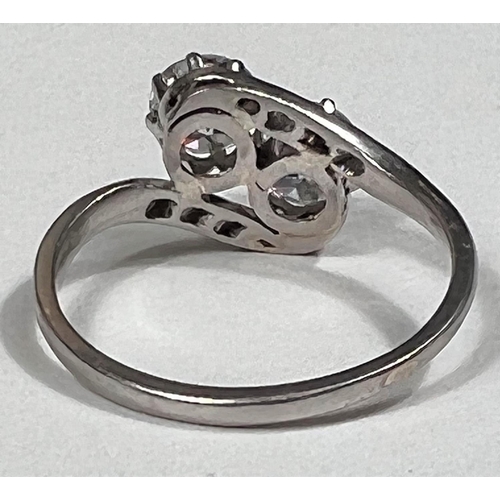 612 - A white metal ring stamped 'Pt', with 2 diamonds in crossover setting, each shoulder set 4 small dia... 