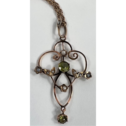 629 - An Edwardian yellow metal pendant set with peridots and seed pearls on yellow metal chain tested as ... 