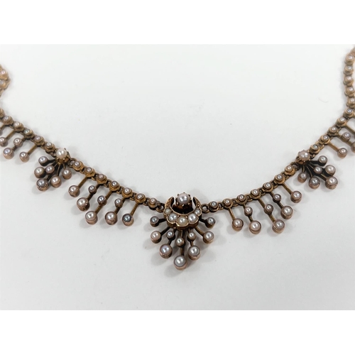 630 - A Victorian yellow metal necklace, each link set with a seed pearl, tiered drops, the central with a... 