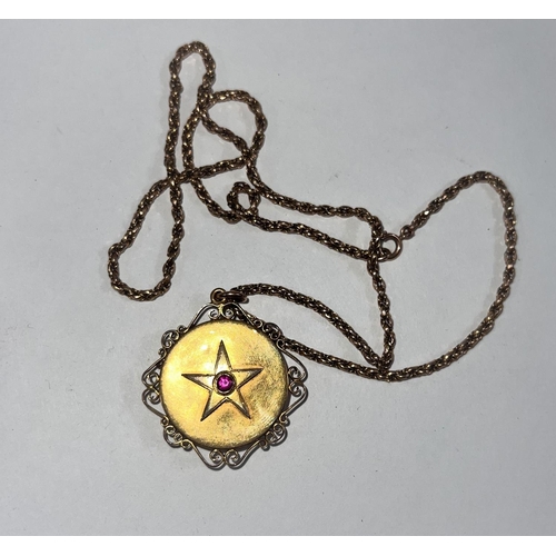 650 - A Victorian 15 carat hallmarked gold pendant/ locket set with a ruby within a star, having scroll fi... 