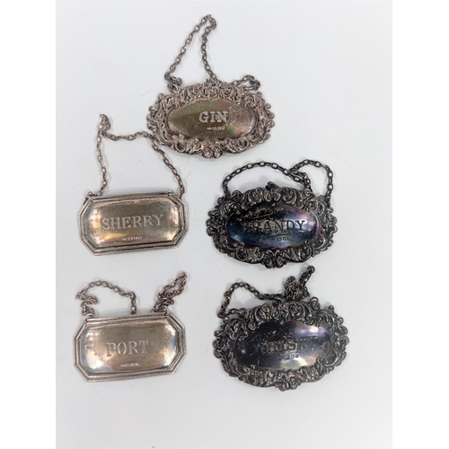 672 - A hallmarked silver set of 3 ornate bottle labels:  Gin, Brandy & Whisky, London 1911-13; a... 