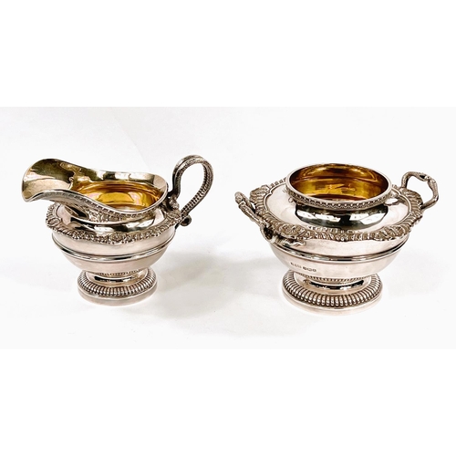 704 - A Georgian style hallmarked silver milk jug and sugar bowl of circular form with gadrooned and shell... 