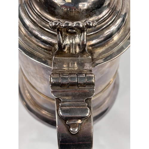 707 - A mid Georgian hallmarked silver quart tankard of ribbed cylindrical form, with hinged lid and swell... 