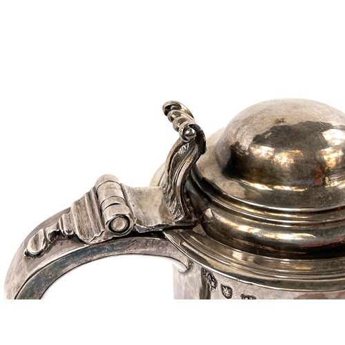 708 - An early Georgian hallmarked silver quart tankard of ribbed cylindrical form, with domed hinged lid ... 