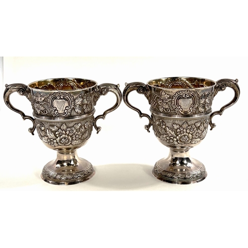 731 - A hallmarked silver pair of Irish cast loving cups with twin handles, extensive relief decoration of... 