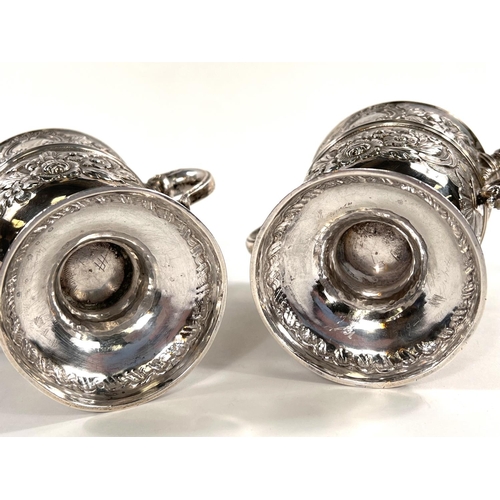 731 - A hallmarked silver pair of Irish cast loving cups with twin handles, extensive relief decoration of... 