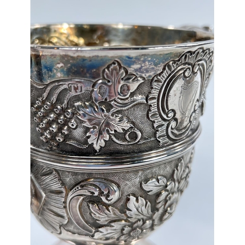 731 - A hallmarked silver pair of Irish cast loving cups with twin handles, extensive relief decoration of... 