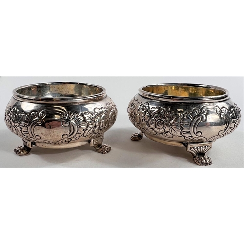 787 - A pair of early 19th century Irish silver salts, repousse decoration with parcel gilt interiors, car... 