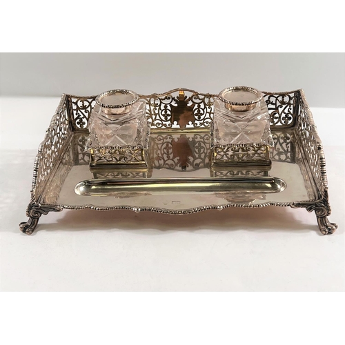 790 - A silver standish with pierced scrollwork gallery and gadrooned border, carried on scrolled feet wit... 