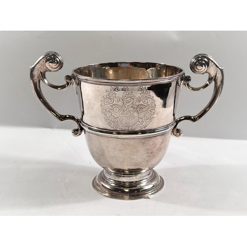 818 - An early 18th century IRISH silver two handled pedestal cup of tapering form with central raised ban... 