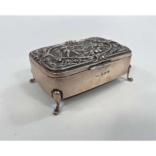 825 - A hallmarked silver hinged box with relief hunting scene to lid, on four feet, Birmingham 1908, leng... 